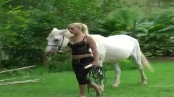 Attractive blonde thrusts enormous horse cock into her two pleasure cavities