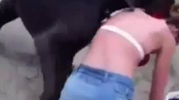 Fair-haired woman in jeans skirt having sex with a black canine on this site