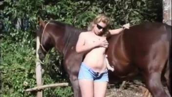 Blond spouse engages closely with a massive equine penis in an outdoor adult film